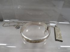 A hallmarked silver ingot on chain together with a hallmarked silver bangle