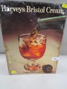 A vintage metal advertising sign laid on card for Harvey's Bristol Cream