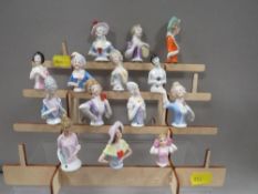Fourteen vintage pin cushion dolls complete with display stand