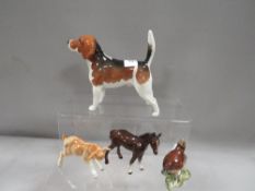 A small collection of Beswick animal figures to include a beagle and a goat