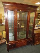 A large modern glazed bookcase display cabinet with three drawers below H 183 cm W 127 cm. A/F