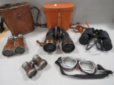 A tray of vintage binoculars together with a pair of vintage motorcycle goggles