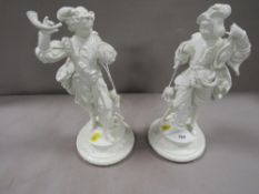 A pair of cast figures overpainted in white