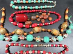 A selection of vintage bead necklaces to include a cherry amber style dropper