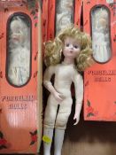 A tray of porcelain dolls in original boxes