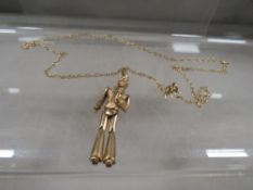A novelty 9 carat gold pendant in the form of Elvis on a chain stamped 375 approx. combined weight