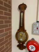 An antique walnut barometer