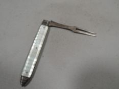 An unusual hallmarked silver and mother of pearl fruit fork