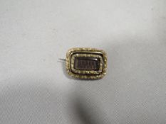 A 19th century mourning brooch set with woven hair