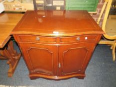 A reproduction serpentine shaped mahogany cabinet W 74 cm