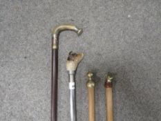 A selection of four walking sticks to include a modern metal one with a Jack Russell head