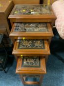 An Eastern nest of four carved tables with glass tops
