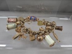 A hallmarked 9 carat gold charm bracelet adorned with approximately with 20 charms approx. weight