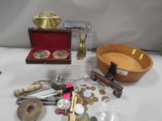 A wooden bowl of collectables, including coins, cigarette lighter etc