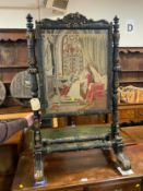 A Victorian carved and gilded revolving fire screen, with two needle point panels depicting
