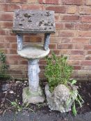 A concrete garden bird feeder and a planter