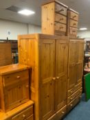 Two honey pine wardrobes together with three honey pine bedside chests