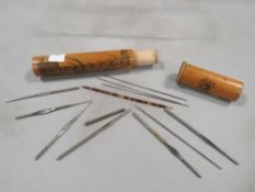 A vintage Mauchlin ware tubular wooden case containing various implements