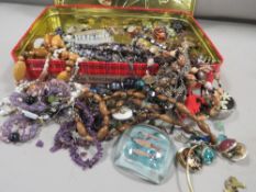 A tin of vintage jewellery