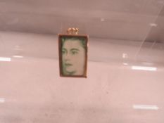 A hallmarked 9ct gold bracelet charm containing £1 note