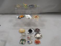 A box of vintage costume brooches