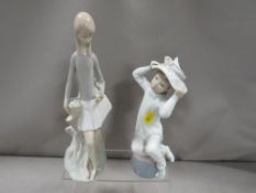 A Lladro figurine of a child trying on a hat together with a Nao figurine of a child holding a bird