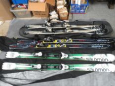 Three pairs of skis with carry bags
