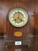 An inlaid domed mantle clock on four brass bun feet