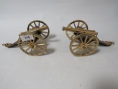 A pair of modern brass and wood desk cannons