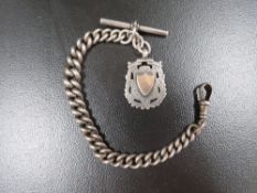 An antique silver pocket watch chain with fob medal