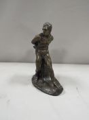 A bronze effect cast figure of a man tied to a tree stump possibly Prometheus ?