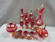 A collection of continental style gilded red glass to include a ewer