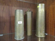 A WW1 1917 trench art shell case gong, along with two large cannon shells (3)