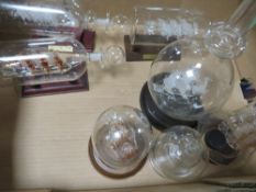 Seven different glass ships in bottles with stands