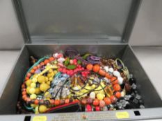 A tin document box of costume jewellery