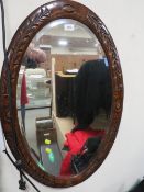 A large oval carved framed wall mirror
