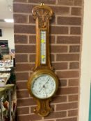 A carved oak android barometer by Ballard of Leominster