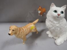 A large Beswick seated cat in white together with a Golden Labrador and a Corgi