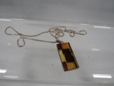 A modern silver pendant set with amber