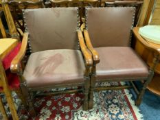 A pair of heavy oak leather studded armchairs