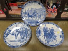 Three Delfts Blauw hand painted equestrian themed chargers together with a tray of blue and white