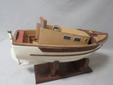 A scratch built motorized model of a trawler boat on display stand