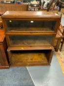 A vintage oak glazed sectional bookcase W 90 cm together with a teak coffee table. (2)