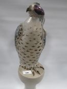 An unusual table lamp in the form of a hooded falcon on stand