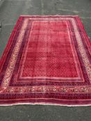 A large red Eastern woollen rug 320 x 210 cm