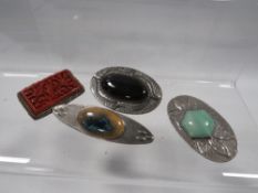 Three arts and crafts brooches together with a cinnabar example (4)