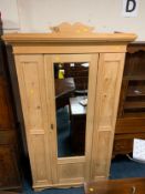 An antique pine mirrored wardrobe