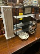 A modern show home hanging shelf together with a slim white cabinet, a toilet roll holder, modern