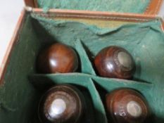 An antique leather cased set of four crown green bowls, with engraved presentation inlay dated 1886