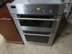 An electric stainless steel larder mounted double oven